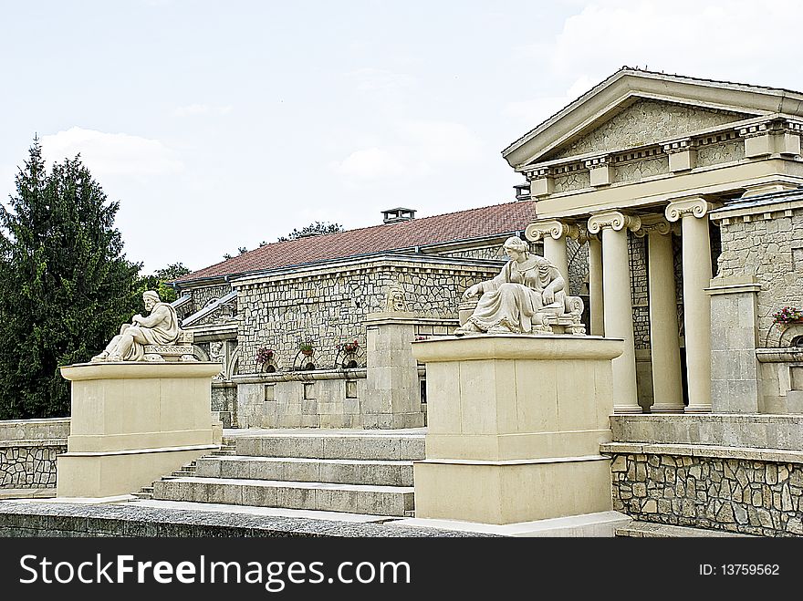 Statue of women and men on the background of an old building