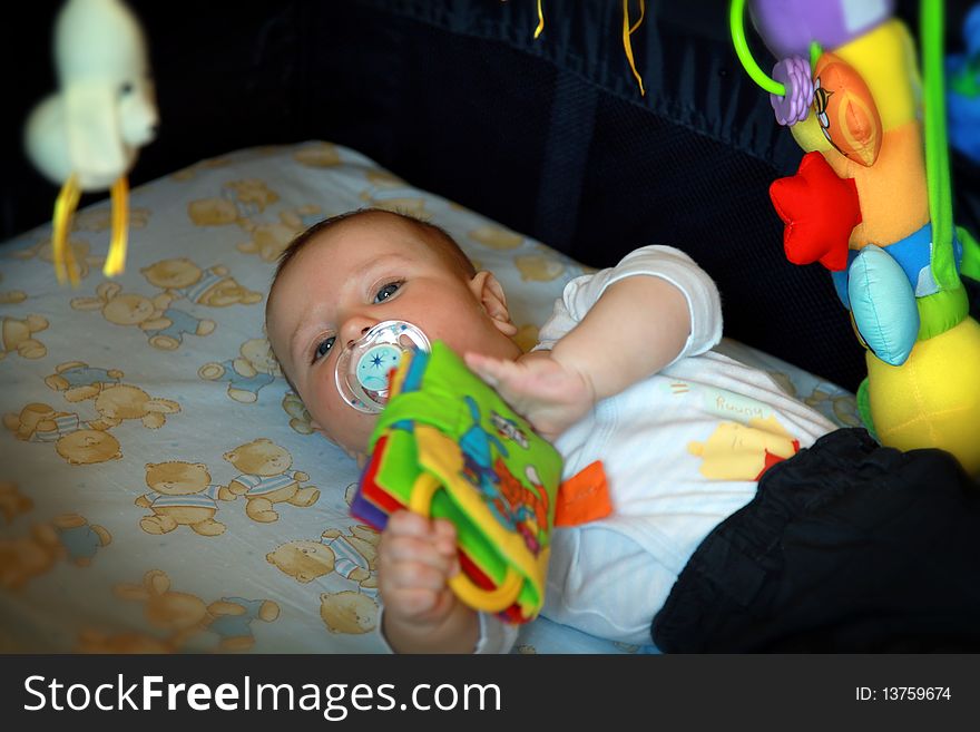 Adorable baby boy playing with his toys