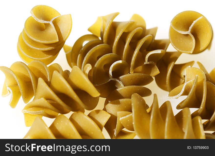 Green pasta spirals against a white background.