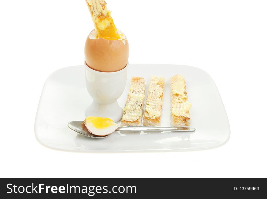 Boiled egg and toast soldiers on a plate isolated against white. Boiled egg and toast soldiers on a plate isolated against white