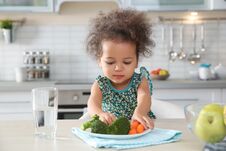 Free Cute African-American Girl Eating Vegetables At Table Stock Photography - 137521952