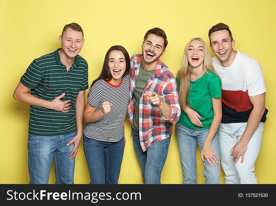 Group of friends laughing together against color background