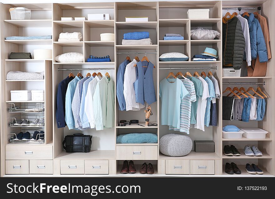 Stylish clothes, shoes and home stuff in large wardrobe closet