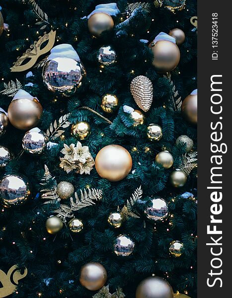 Fluffy fir decorated on theater theme with gold baubles, mask and leaves close up. Christmas and new year background. New year background