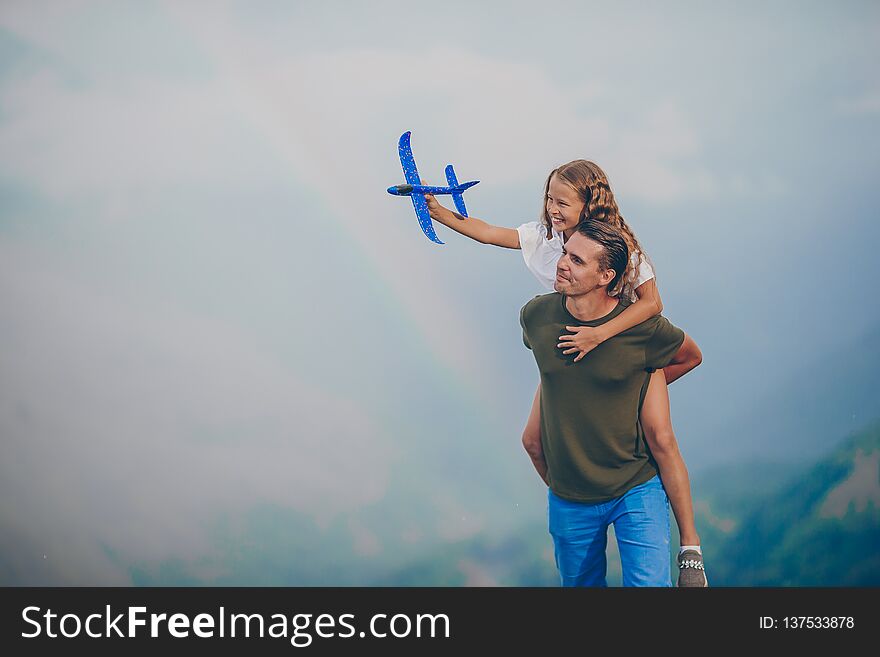 Beautiful little girl and young father in mountains in the background of fog