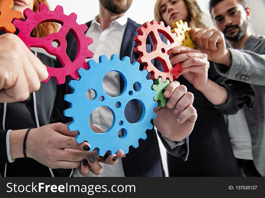 Teamwork of businesspeople work together and combine pieces of gears. Partnership and integration concept. Teamwork of businesspeople work together and combine pieces of gears. Partnership and integration concept
