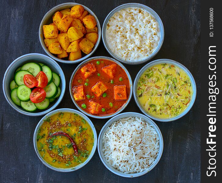 North Indian cuisine - matar paneer or cottage cheese curry,fried potato sides,yogurt dip,kheer dessert,jeera rice,dal fry lentils. North Indian cuisine - matar paneer or cottage cheese curry,fried potato sides,yogurt dip,kheer dessert,jeera rice,dal fry lentils