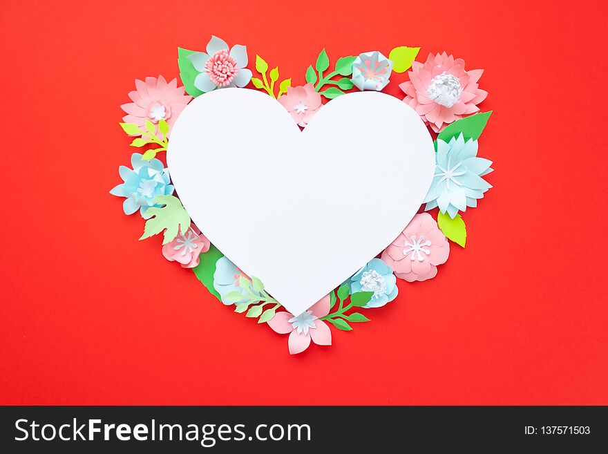 Heart frame with paper flowers on red background. Cut from paper