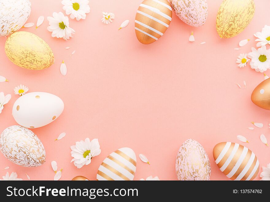 Flat Lay of Golden Easter Eggs with small flowers and petals on pink background. Easter background or easter concept. Flat Lay of Golden Easter Eggs with small flowers and petals on pink background. Easter background or easter concept