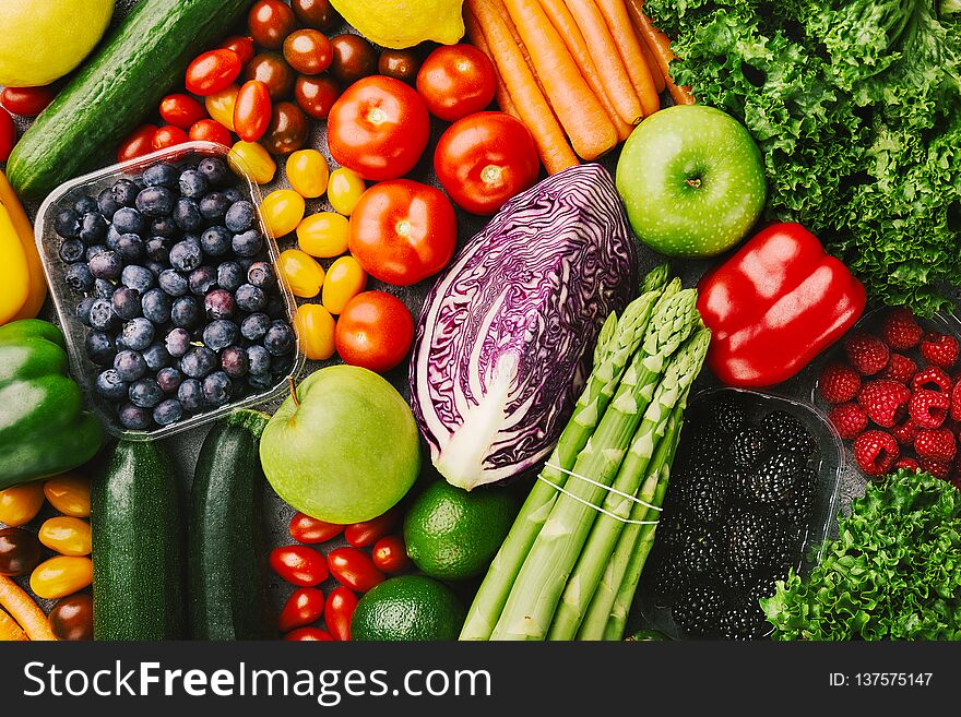 Arrangement of different colorful tasty vegetables and berries on grey concrete rough background. Top View with Copy Space. Healthy Food Concept. Studio Shot. Arrangement of different colorful tasty vegetables and berries on grey concrete rough background. Top View with Copy Space. Healthy Food Concept. Studio Shot