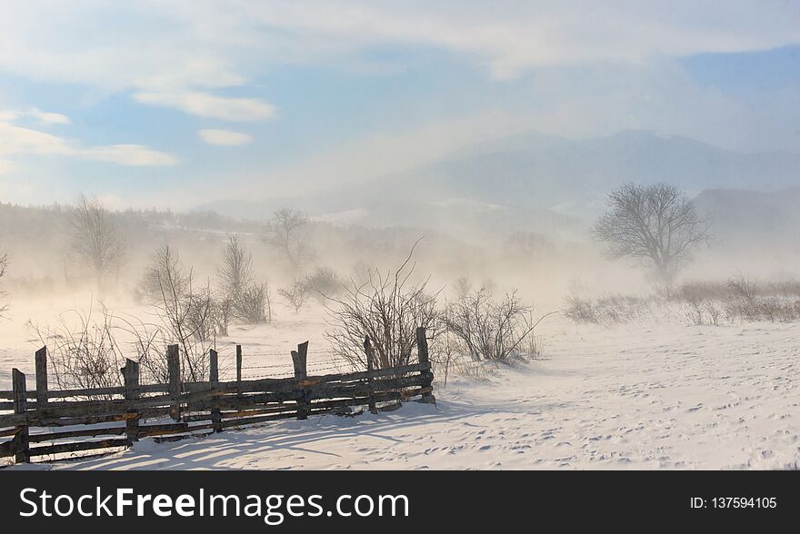 Winter Field In A Storm In Mountains