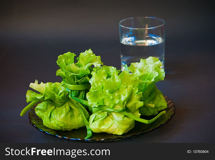 Close-up bags made of lettuce filling with cheese and a glass of water. Close-up bags made of lettuce filling with cheese and a glass of water