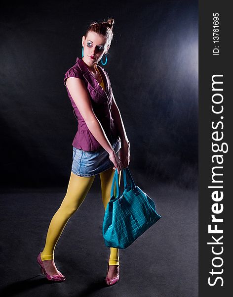 Fashion photo, model with a bag posing on light background. Fashion photo, model with a bag posing on light background