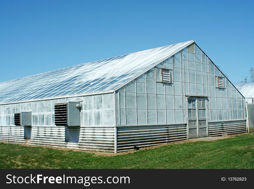 A green house with blue sky. A green house with blue sky
