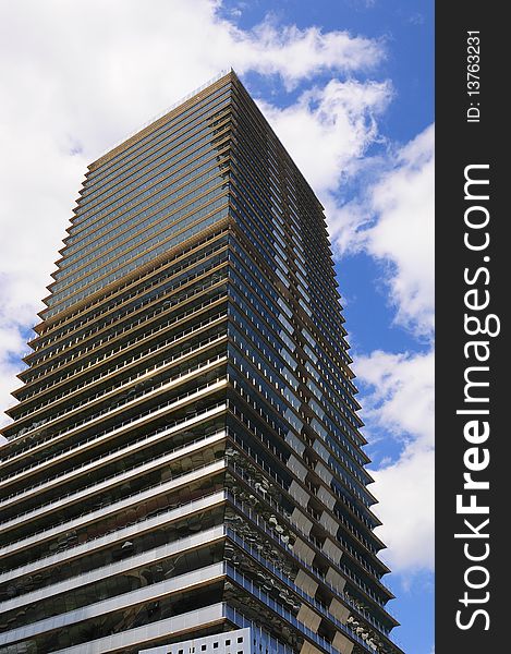 A modern looking skyscraper etched against a cloudy sky. A modern looking skyscraper etched against a cloudy sky.