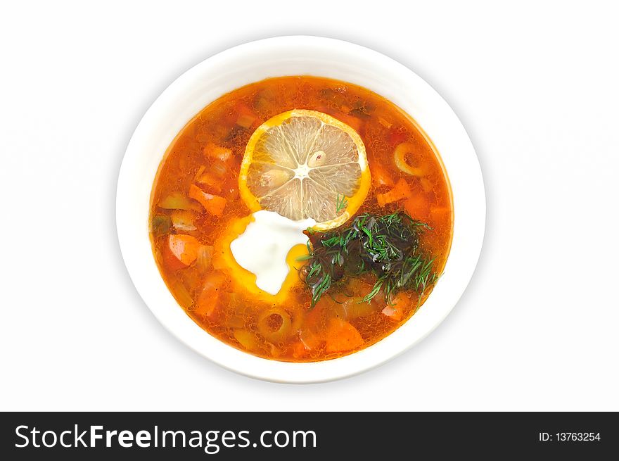 Soup with lemon and olives in a white plate on a white background  close up