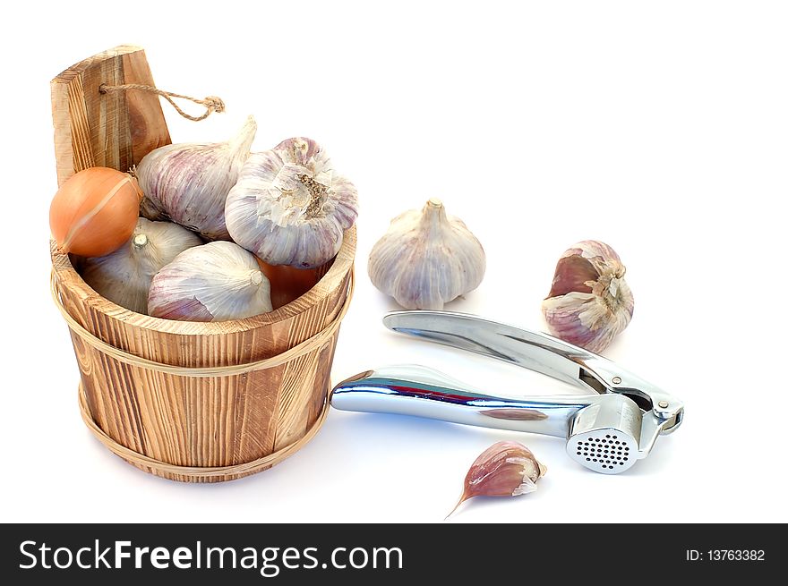 Wooden bucket with garlic heads on a white background