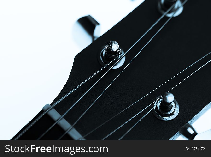 Guitar machine heads and strings against a white background.