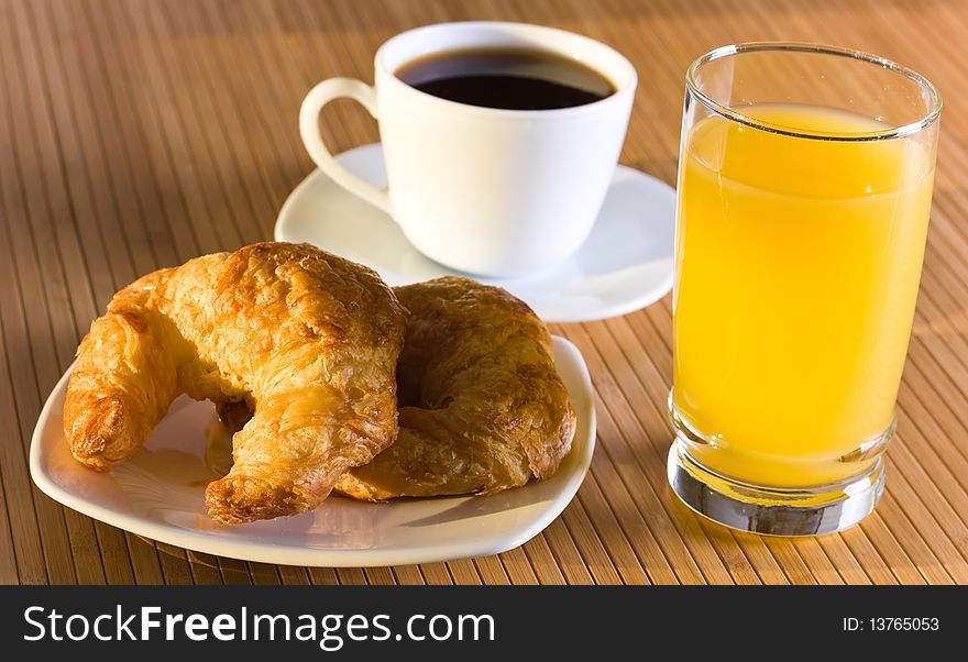 Breakfast with orange juice, coffee and croissants.