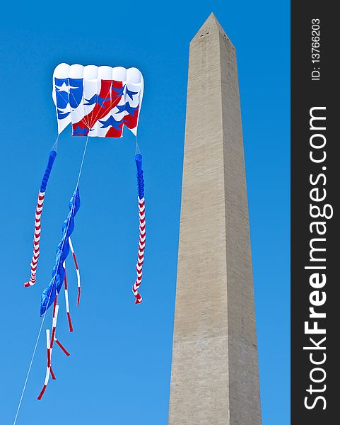 Large patriotic kite captured being flown next to Washington Monument.