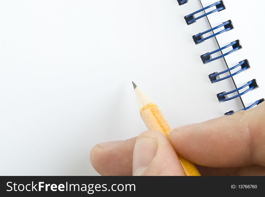 Pencil in hand and notebook on white background