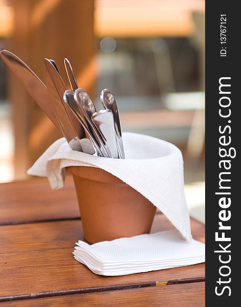 Original table setting knives and forks in a clay pot