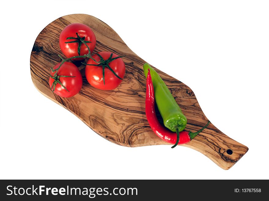 Three fresh red tomato and Chili pepper on breadboard