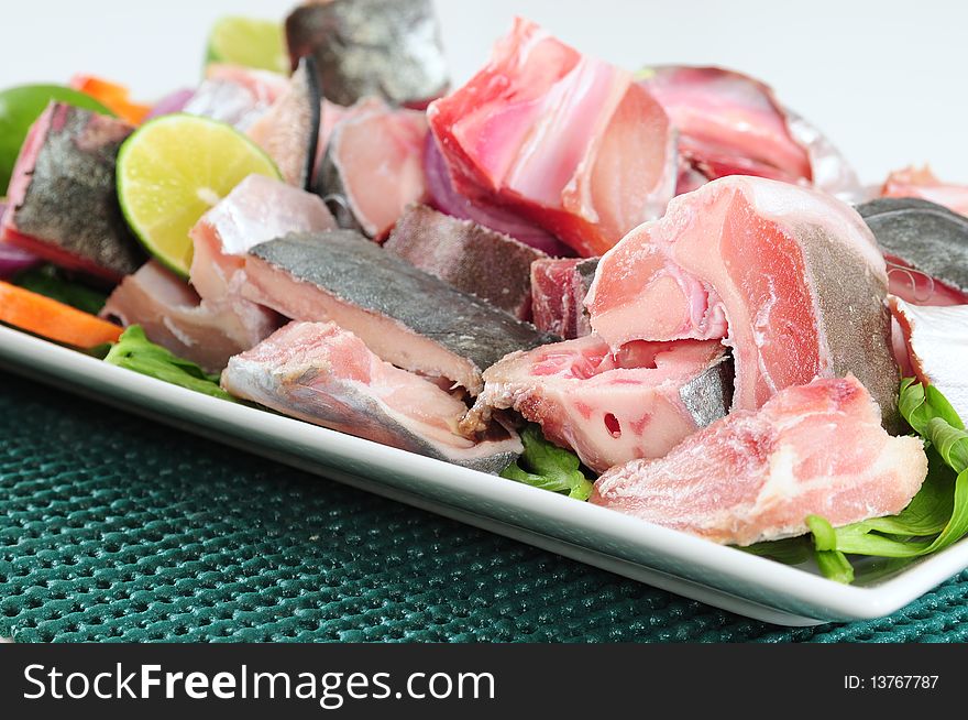 Slices of raw fish with bones and vegetables. Slices of raw fish with bones and vegetables.