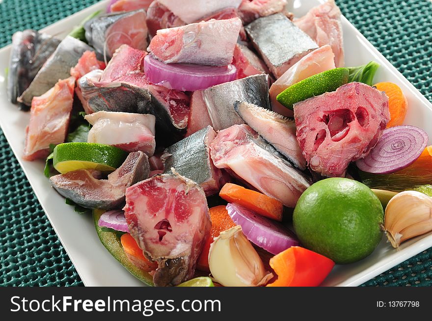 Slices of raw fish with bones and vegetables. Slices of raw fish with bones and vegetables.