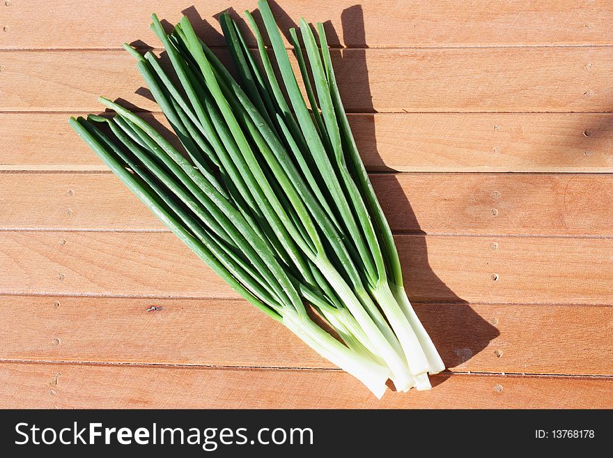 Bunch of spring onions on a wooden table