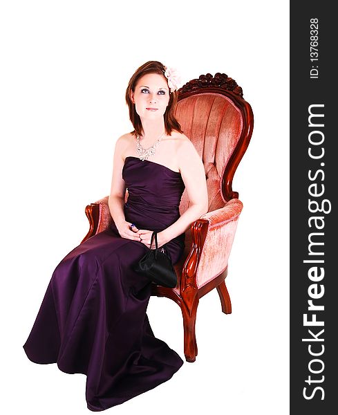 An young pretty woman in a burgundy long evening dress sitting in a 
antic pink armchair for white background. An young pretty woman in a burgundy long evening dress sitting in a 
antic pink armchair for white background.