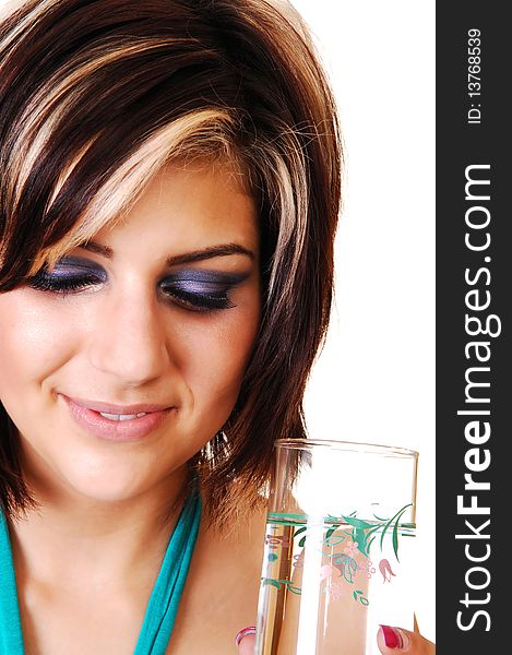 An pretty smiling girl with a glass full of water, in a closeup shot, standing in the studio and looking down, for white background. An pretty smiling girl with a glass full of water, in a closeup shot, standing in the studio and looking down, for white background.