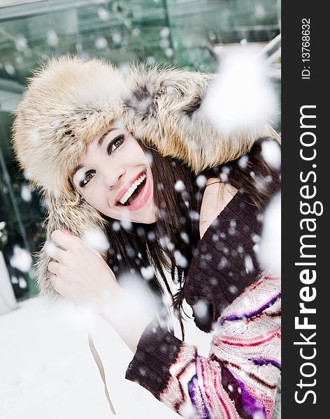 Smiling young woman in falling snow