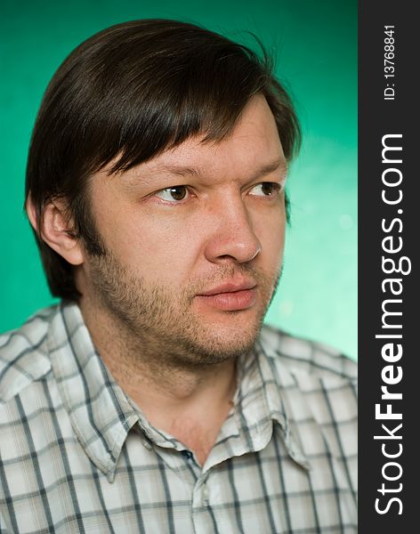 Portrait of the serious young man on green background. Focus on eyes, small depth of feild. Portrait of the serious young man on green background. Focus on eyes, small depth of feild.