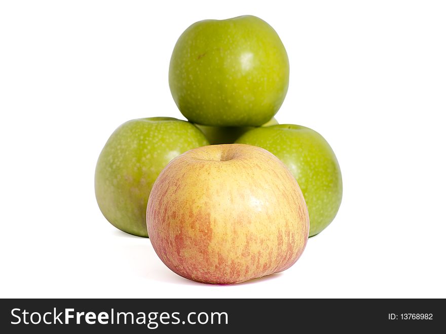 Four tasty green apples and one red apple piled on a white background