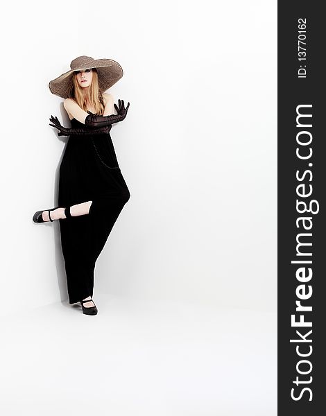 Portrait of a beautiful girl in elegant black dress and a  hat. Portrait of a beautiful girl in elegant black dress and a  hat.