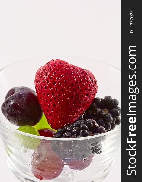 Fresh fruit in a clear crystal glass isolated on white background.