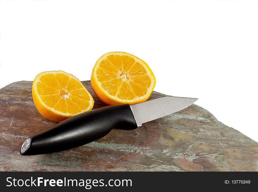 Orange cut in half with knife in foreground. Orange cut in half with knife in foreground..