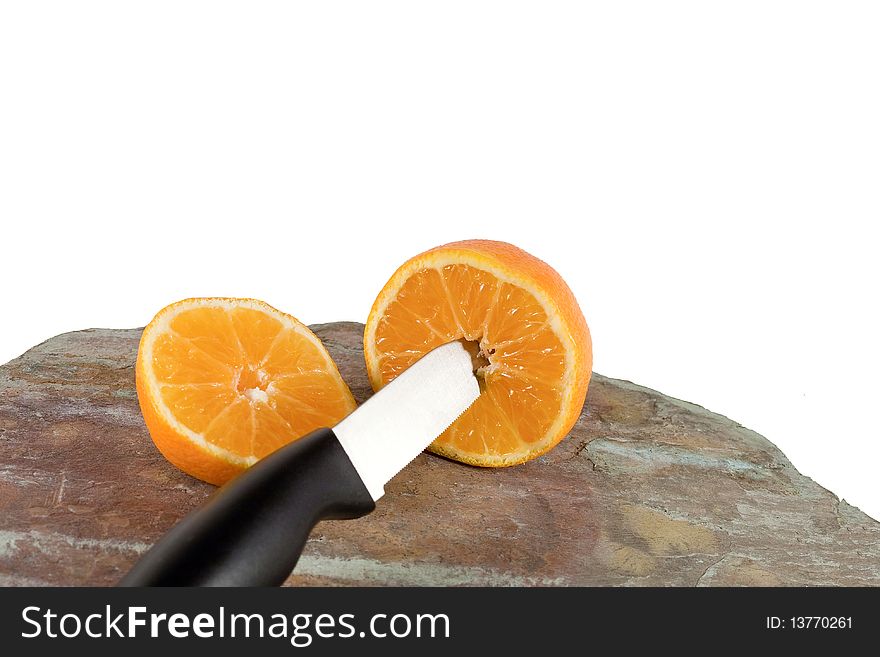 Orange cut in half with knife in foreground. Orange cut in half with knife in foreground..