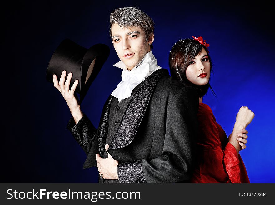 Portrait of a beautiful couple in medieval costumes with vampire style make-up. Shot in a studio. Portrait of a beautiful couple in medieval costumes with vampire style make-up. Shot in a studio.