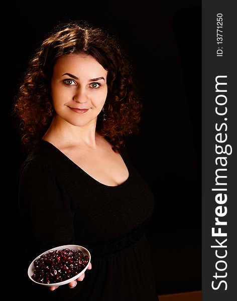 Portrait of a young woman with seeds of pomegranate. Studio shot.