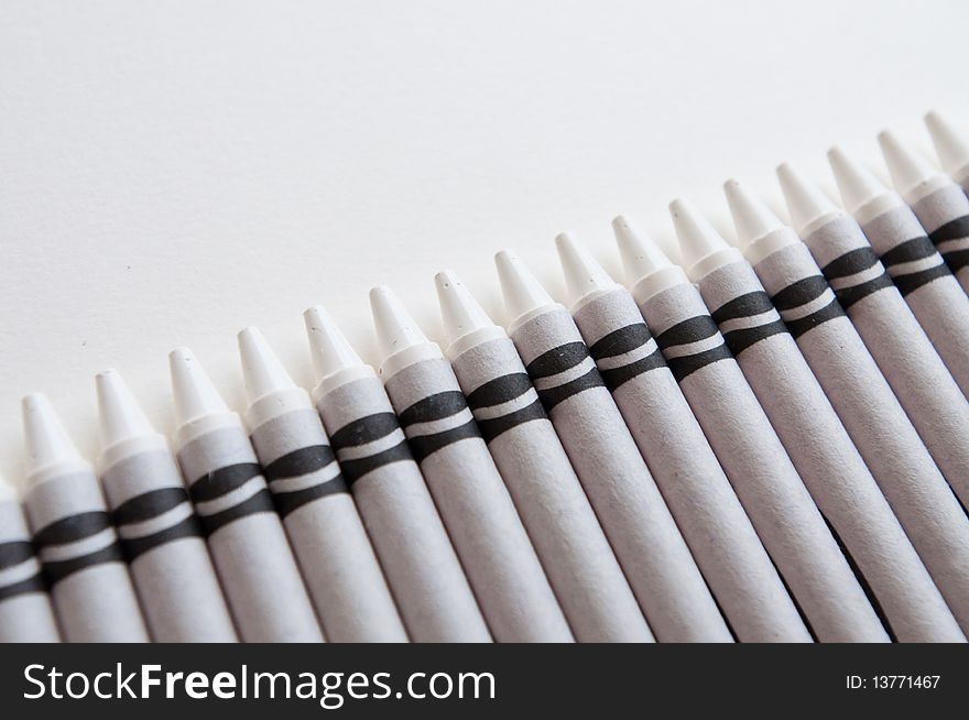 A row of all white crayons against a white background