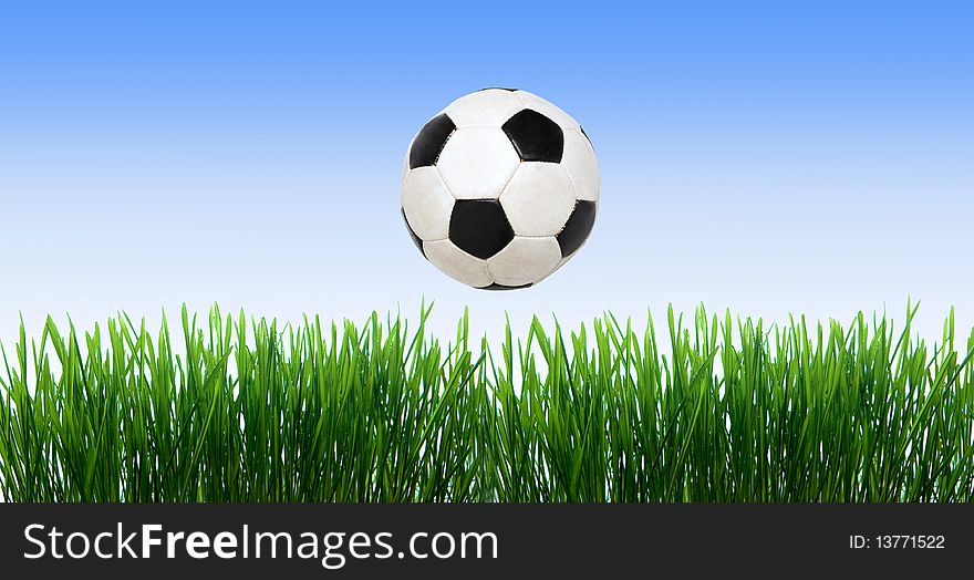 Soccer ball on the green field with grass