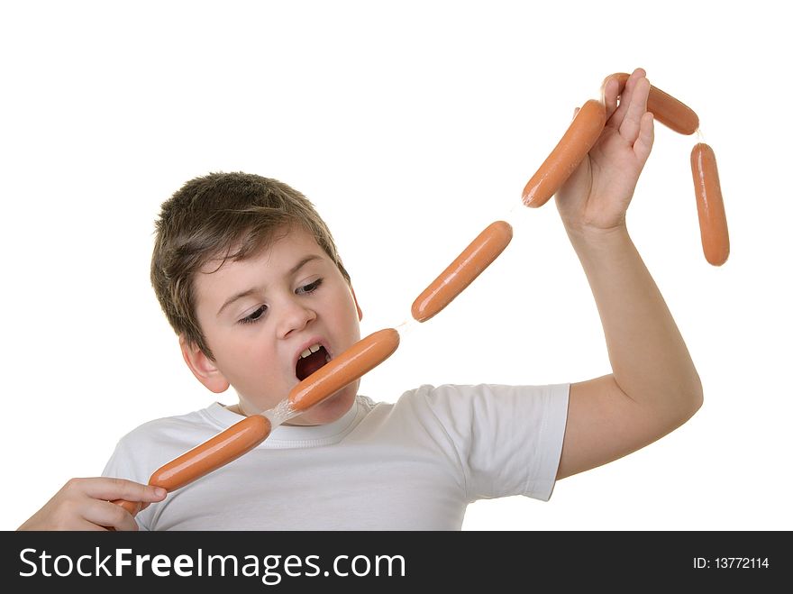 Hungry boy bites sausage isolated in white