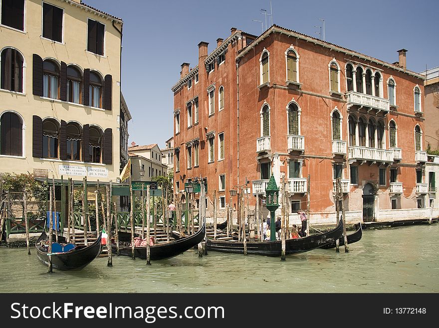 Gondolas at Grand Canal among old and multicolored houses in Venice, Italy. Gondolas at Grand Canal among old and multicolored houses in Venice, Italy