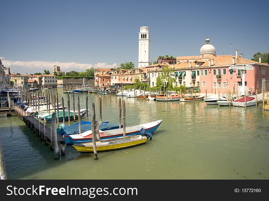 Boats at venetian canal among old and multicolored houses in Venice, Italy. Boats at venetian canal among old and multicolored houses in Venice, Italy