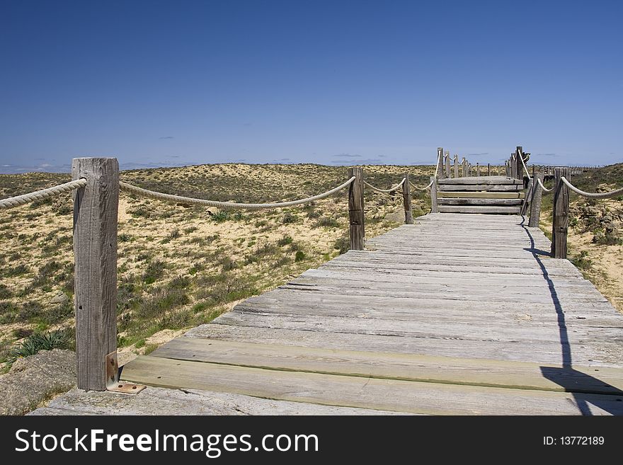 Wood path going to a wild and empty beach. Wood path going to a wild and empty beach