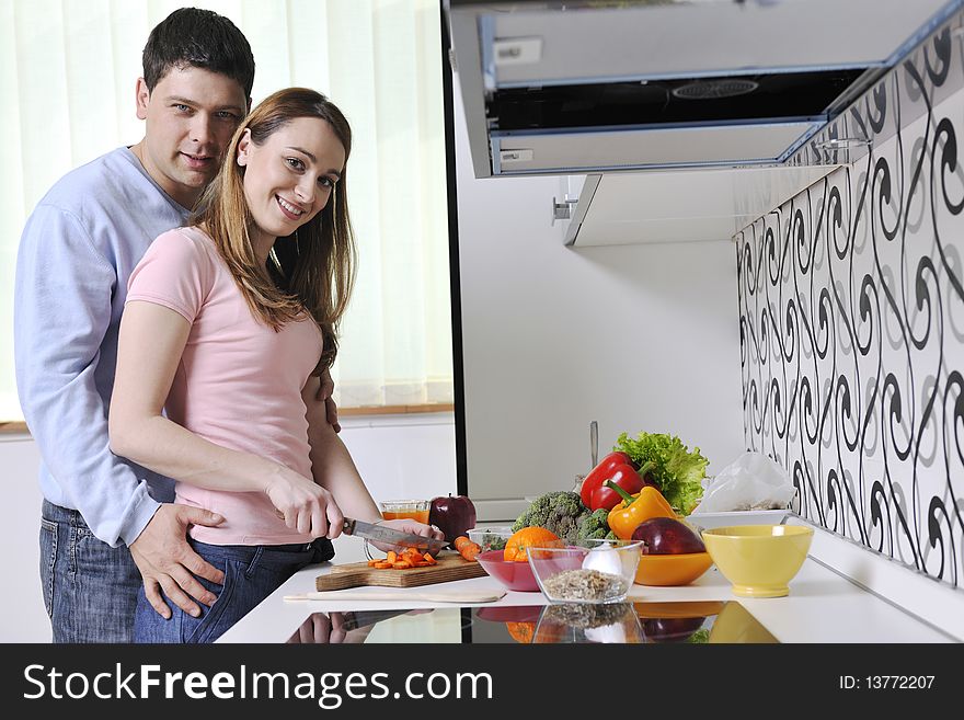 Couple have fun preparing healthy food in kitchen