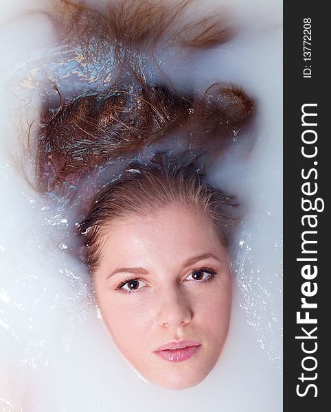 Beauty woman in bathroom with water with milk