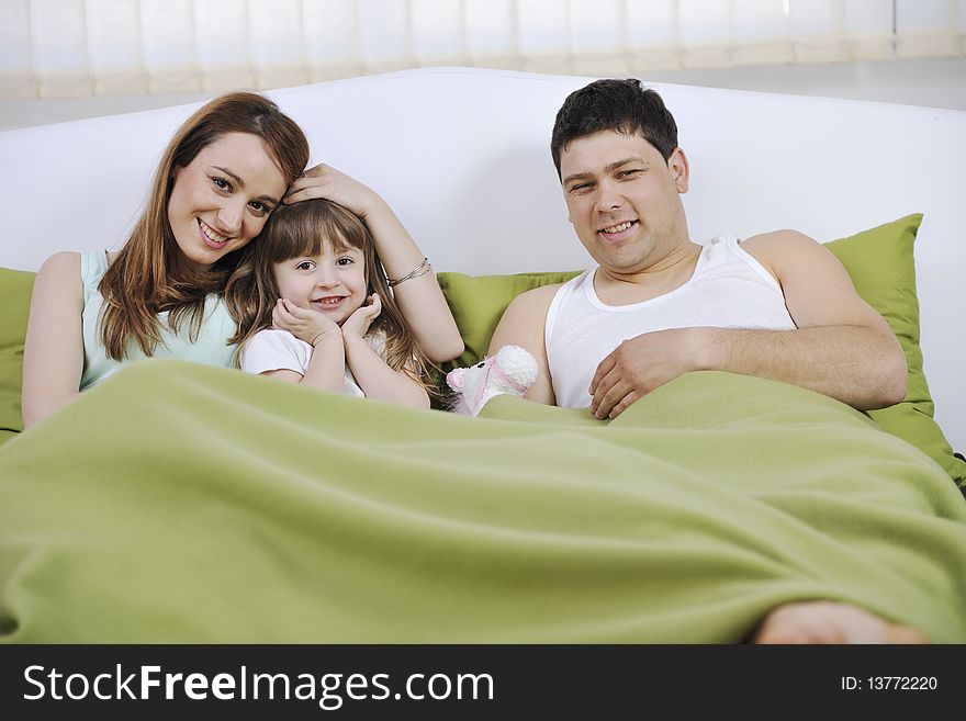 Happy young family relaxing in bed. Happy young family relaxing in bed